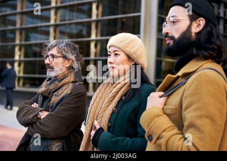 Eine multiethnische Gruppe von drei Personen unterschiedlichen Alters in einem Business-Center, das für ein Foto posiert. Stockfoto