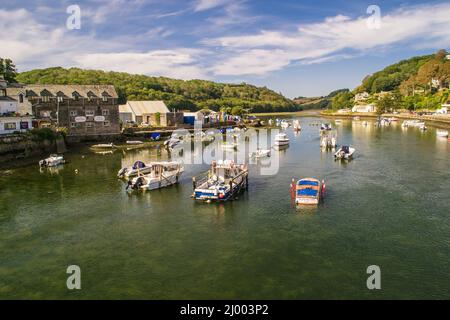 Blick von der Brücke in Looe auf die Flussmündung auf all die kleinen Boote, die im Fluss festgemacht sind. Stockfoto