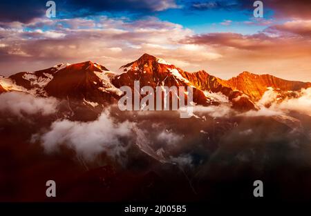 Ein Blick auf die sonnenbeschienenen Hügel in der Dämmerung. Dramatische Abendszene. Lage Ort Großglockner Hochalpenstraße, Österreich. Europa. Klimawandel. Drohne Stockfoto