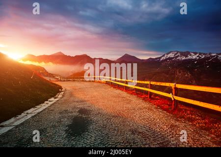 Ein Blick auf die sonnenbeschienenen Hügel in der Dämmerung. Dramatische und wunderschöne Morgenszene. Lage Ort Großglockner Hochalpenstraße, Österreich. Sightseeing Europ Stockfoto