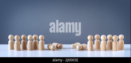 Abstrakte Fotografie mit Figuren von Holzmännern auf grauem Hintergrund. Stockfoto