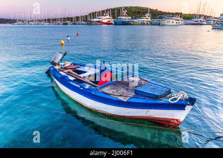 Altes Fischerboot im Hafen. Sonnenuntergang über der Meeresbucht im Dorf Rogoznica, ein beliebtes Touristenziel an der dalmatinischen Küste der Adria Stockfoto