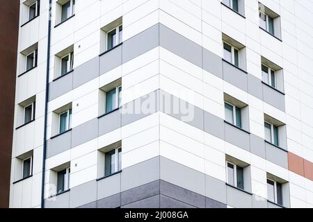 Fragment der Fassade eines renovierten und wärmegedämmten mehrstöckigen Mehrfamilienhauses Stockfoto