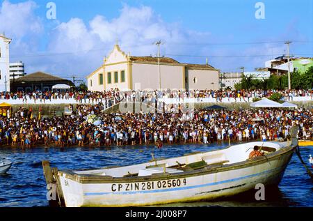 Die Gemeinde an der Küste wartet darauf, dass die Saveiros, traditionelle Segelboote, auf See auslaufen, um die Opfergaben der Göttin Iemanja zu überlassen. Jedes Jahr, am 2. Februar, feiert die Stadt Salvador, Bahia, den Tag der Iemanja. Die Feier am Strand von Rio Vermelho ist ein vielfältiges Ritual, das nicht nur Menschen aus ganz Brasilien anzieht, sondern auch Ausländer aus dem Rest der Welt neugierig macht, ihre Opfer der Meeresgöttin zu überlassen. 2. Februar 2008. Salvador, Brasilien. Stockfoto