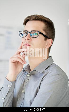 Was wäre, wenn Ausgeschnittene Aufnahme eines jungen Geschäftsmannes mit nachdenklicher Optik. Stockfoto