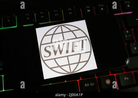 Viersen, Deutschland - März 9. 2022: Blick auf Handy-Bildschirm auf Computer-Tastatur mit Logo der Interbank-Gesellschaft SWIFT Stockfoto