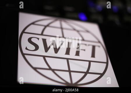 Viersen, Deutschland - März 9. 2022: Blick auf Handy-Bildschirm auf Computer-Tastatur mit Logo der Interbank-Gesellschaft SWIFT Stockfoto