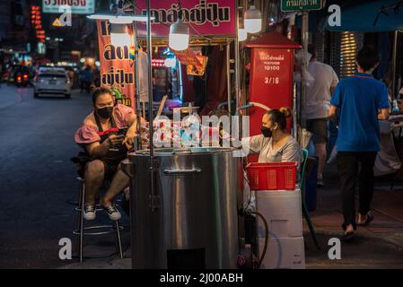 Bangkok, Thailand. 15. März 2022. Händler sahen, wie sie neben ihrem Straßenstand in Bangkoks Chinatown auf Kunden warteten. Chinatown, auch bekannt als Yaowarat, ist das berühmte Ziel für Touristen in der Nacht mit vielen Straßenrestaurants und chinesischen Restaurants. (Foto von Peerapon Boonyakiat/SOPA Images/Sipa USA) Quelle: SIPA USA/Alamy Live News Stockfoto