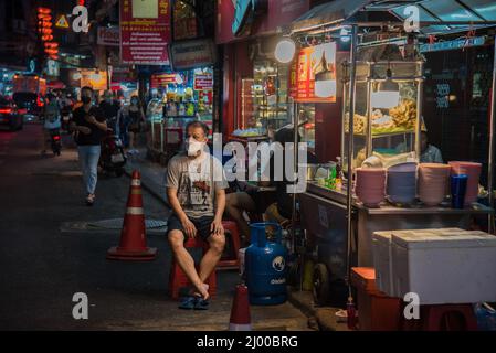 Bangkok, Thailand. 15. März 2022. Ein Verkäufer sah, wie er neben seinem Straßenstand in Bangkoks Chinatown auf Kunden wartete. Chinatown, auch bekannt als Yaowarat, ist das berühmte Ziel für Touristen in der Nacht mit vielen Straßenrestaurants und chinesischen Restaurants. (Bild: © Peerapon Boonyakiat/SOPA Images via ZUMA Press Wire) Stockfoto