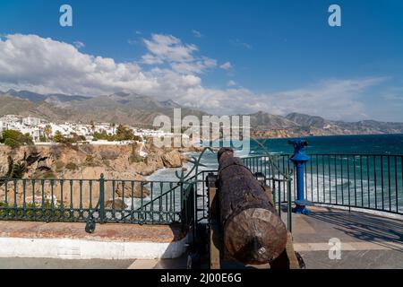 Blick vom Balkon Europas in Nerja, Malaga. Statue von König Alfonso XII. Alte Holzkanone. Sierra Nevada Berge im Hintergrund Stockfoto