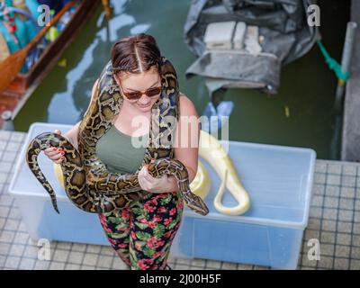 Begegnung mit Python-Schlangen auf dem schwimmenden Markt von Damnoen Saduak. Stockfoto