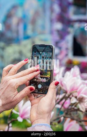 Frauen Hände mit Smartphone fotografieren lebendige szenische Architektur. Moderne Technik, Frühling Stockfoto