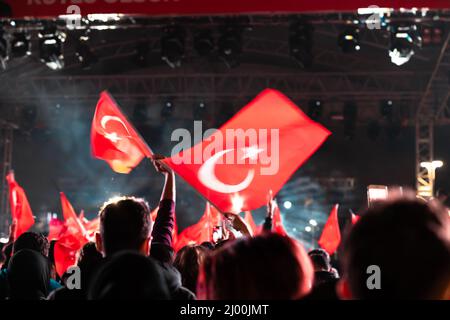 Türkische Flaggen winken bei einer Veranstaltung in der Nacht. Wir feiern die türkischen Nationalfeiertage. Bewegungsunschärfe auf den Flaggen. Selektiver Fokus. Lärm inklusive. 23 nisan, 19 Stockfoto