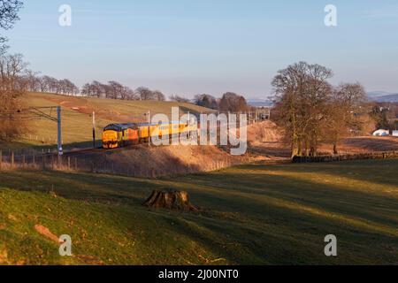 2 Colas Railfreight Klasse 37 Lokomotiven, die Cleghorn, Lanark an der Hauptlinie der Westküste mit einem Network Rail Infrastructure Monitoring Testzug passieren Stockfoto