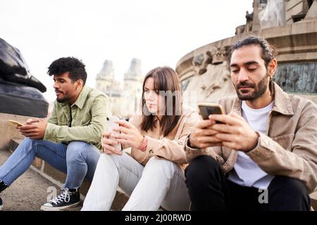 Individualistische Menschen chatten mit Smartphones und ignorieren sich gegenseitig mit dem Handy. Individualistische Freunde Techniksüchtige Stockfoto