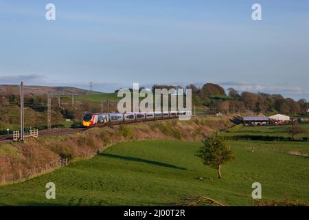 Virgin fährt den elektrischen Pendolino-Zug der Alstom-Klasse 390 durch die Landschaft an der Hauptlinie der Westküste in Lancashire Stockfoto