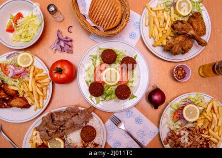 Abbildung: Set von Kebab-Gerichten auf dem Teller, mit gegrilltem Brot und mit Hähnchenflügeln und pommes frites Stockfoto