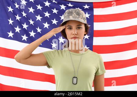 Begrüßende afroamerikanische Soldatinnen gegen die US-Flagge Stockfoto