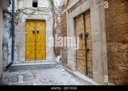 Traditionelle blaue Tür eines antiken Hauses in einer Gasse der Medina (Altstadt) von Tunis, Tunesien. Stockfoto