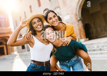 Eine multiethnische Gruppe von drei glücklichen jungen Frauen, die Spaß in den Sommerferien haben Stockfoto