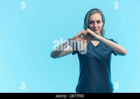 Weibliche Chirurgen trägt schützende Gesichtsmaske und Schutzanzug Porträt auf blauem Hintergrund. Hochwertige Fotos Stockfoto