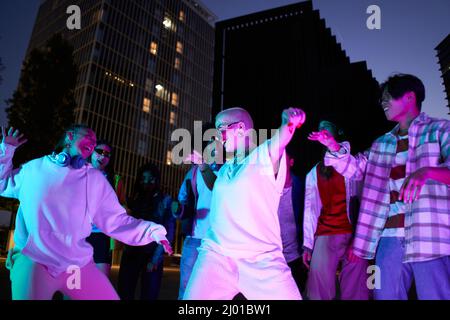 Junge Menschen tanzen bei einer Party-Nacht in der Stadt. Moderne multikulturelle Freunde, die gemeinsam Musik genießen Stockfoto