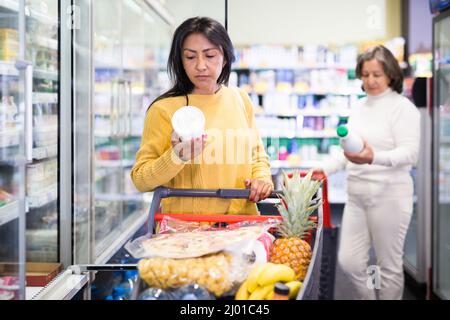 Weibliche Shopper wählt Milchprodukte im Supermarkt Stockfoto