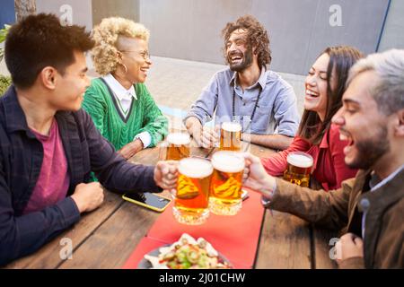Glückliche Freunde, die Spaß im Freien haben. Junge Menschen genießen Zeit zusammen draußen, Jugend Freundschaft Konzept. Hände toasten Bier. Stockfoto