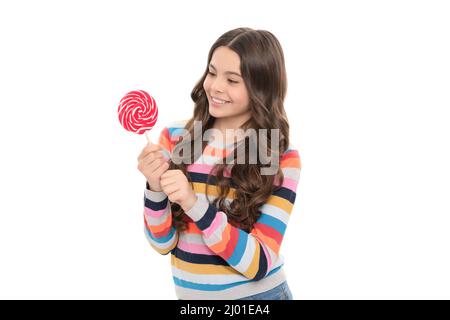 Happy teen Mädchen in Pullover mit Lutscher Süßigkeiten auf Stick isoliert auf weißem Hintergrund, Süßigkeiten-Shop. Stockfoto