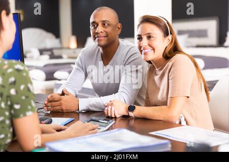 Das Paar kommuniziert mit dem Matratzenverkäufer Stockfoto
