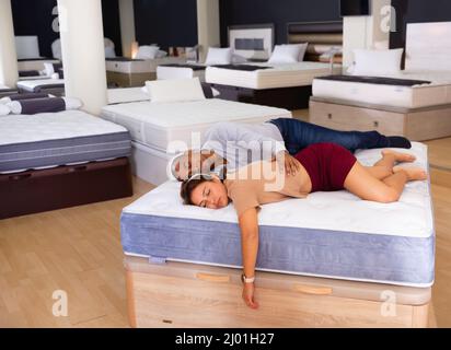 Mann und Frau schliefen auf einer neuen Matratze in einem Möbelgeschäft ein Stockfoto