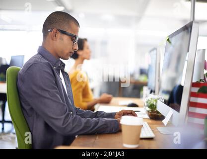 Sich auf seine Arbeit konzentrieren. Eine junge Designerin, die im Büro arbeitet. Stockfoto