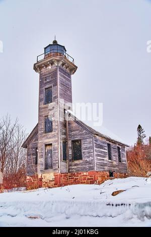 Altes verlassene Lichthaus im Winter auf der Insel während des Schnees Stockfoto