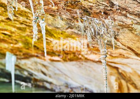 Kleine schmelzende Eiszapfen auf der Felsoberfläche Stockfoto