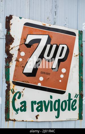 Vintage 7up Softdrink Unternehmen rechteckige Metall-Werbung Zeichen für Französisch sprechenden Verbrauchermarkt an der Außenwand der Garage geschrieben. Stockfoto