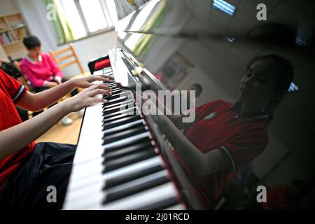 (220316) -- YINCHUAN, 16. März 2022 (Xinhua) -- Ma Yifei spielt Klavier während eines Musikunterlags in Yinchuan, der Autonomen Region Ningxia Hui im Nordwesten Chinas, am 16. Mai 2018. Für Ma Yifei, ein 16-jähriges sehbehindertes Mädchen, ist das Violinstück des Pekinger 2022-Titelliedes Snowflake, das sie bei der Abschlusszeremonie der Paralympischen Winterspiele 2022 in Peking spielte, ihr bestes Geschenk für Paralympier auf der ganzen Welt. MA, ein Zweitstudium an der Ningxia Fachhochschule im Nordwesten Chinas, der Autonomen Region Ningxia Hui, verlor im Alter von zwei Jahren durch Krankheit ihr Augenlicht. Mit der Hoffnung t Stockfoto