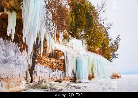 Atemberaubende Klippen im Winter mit Eiszapfen und gefrorenen blauen Wasserfällen bedeckt Stockfoto