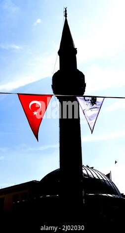 Izmir, Türkei, Türkei. 13. März 2022. Eine Silhouette eines Minaretts mit türkischer Flagge und einem Wimpel von Atatürk (Bild: © Idil Toffolo/Pacific Press via ZUMA Press Wire) Stockfoto