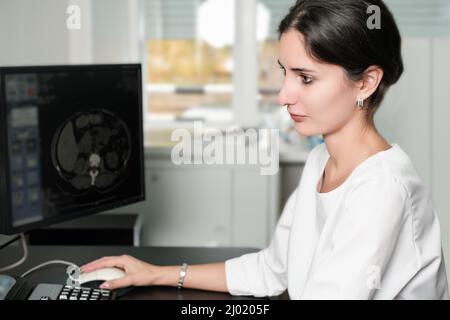 Radiologin Frau beim Lesen eines CT-Scans. Ärztin, die CT-Scans vom Kontrollraum im Krankenhaus ausführt Stockfoto