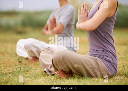 Sich um Körper und Geist kümmern. Frauen machen Yoga im Freien. Stockfoto