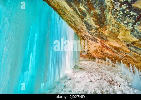Atemberaubende blaue Eisdecke bedeckt den Eingang zur Höhle im Winter Stockfoto