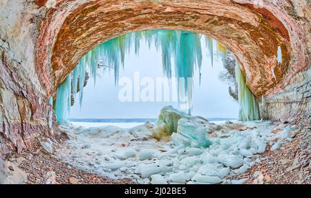 Öffnung zur großen Eishöhle in Michigan mit blauen und grünen Eiszapfen-Formationen Stockfoto