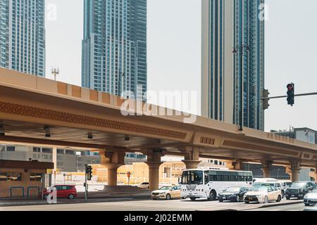 Dubai, VAE, Vereinigte Arabische Emirate - 28. Mai 2021: Bus und Autos bewegen sich auf der Straße zwischen gläsernen Wolkenkratzern in Dubai. Verkehr auf der Straße in Dubai. Stadt Stockfoto
