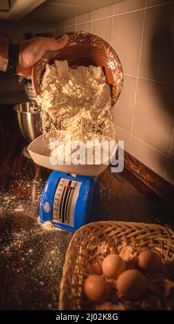 Vertikale Aufnahme des professionellen Küchenchefs, der alle Zutaten in der Küche zum Backen auslegt Stockfoto