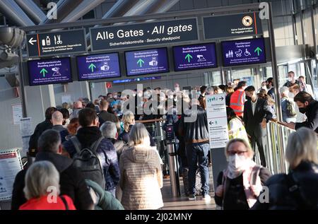 Hamburg, Deutschland. 16. März 2022. Reisende stehen in einer langen Schlange vor der Sicherheitskontrolle am Hamburg Airport. Nach den Warnstreiks der Verdi-Gewerkschaft der Sicherheitskräfte in der Passagierkontrolle gab es heute Morgen am Hamburger Flughafen lange Wartezeiten. Quelle: Christian Charisius/dpa/Alamy Live News Stockfoto