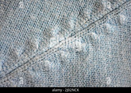 Strickwaren, hellblauer Damen-Wollpullover mit interessanten Mustern, Stricken in Form eines Zöpfels, geraffte Gummizüge, verschiedene Webstoffe. Stockfoto