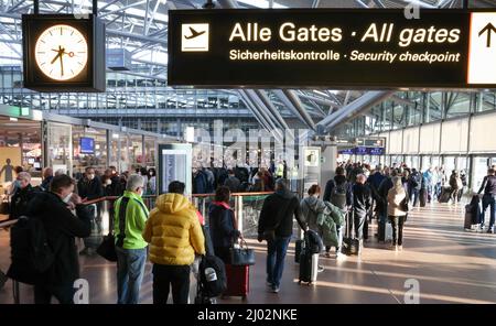 Hamburg, Deutschland. 16. März 2022. Reisende stehen in einer langen Schlange vor der Sicherheitskontrolle am Hamburg Airport. Nach den Warnstreiks der Verdi-Gewerkschaft der Sicherheitskräfte in der Passagierkontrolle gab es heute Morgen am Hamburger Flughafen lange Wartezeiten. Quelle: Christian Charisius/dpa/Alamy Live News Stockfoto