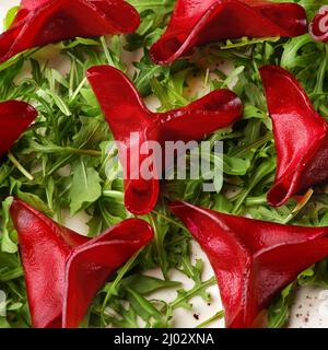 Rote Beete Ravioli gefüllt mit weißer Sauce und Pesto auf dem Tisch im Restaurant Stockfoto