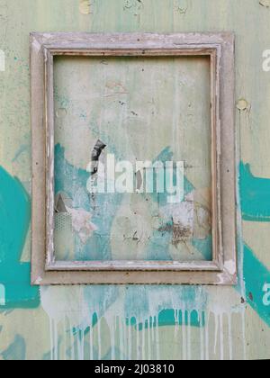 Verwitterter Bilderrahmen an einer Holzwand / verwitterter Bilderrahmen an einer Holzwand Stockfoto