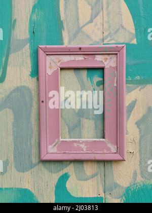 Verwitterter Bilderrahmen an einer Holzwand / verwitterter Bilderrahmen an einer Holzwand Stockfoto